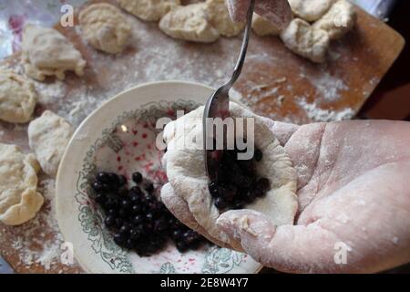 Hausgemachte Knödel sind hässlich mit Heidelbeeren Kochen zu Hause Lebensmittel Verpackung Knödel. Stockfoto