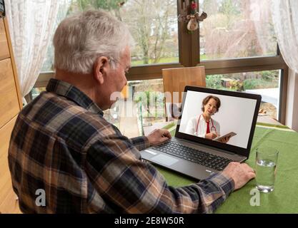 Symbolisches Bild der Telemedizin, ältere Patienten spricht mit einem Arzt in einer Videokonferenz, von zu Hause, Stockfoto