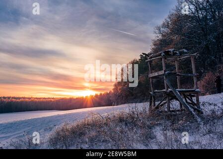 Hoher Sitz in einer Winterlandschaft am Waldrand im Sonnenuntergang. In einem Winterwunderland. Stockfoto