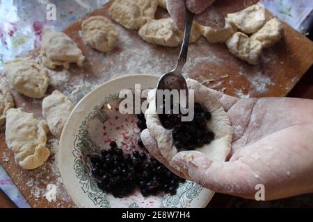 Hausgemachte Knödel sind hässlich mit Heidelbeeren Kochen zu Hause Lebensmittel Verpackung Knödel. Stockfoto