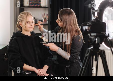 Frau Make-up für attraktive blonde Haare Frau im Studio. Video von Make-up-Künstler Anwendung Kosmetik für schöne Modell Stockfoto