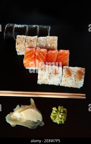 Food Hintergrund Set Sushi-Rolle mit Lachs. Sushi-Menü. Japanisches Essen. Schwarzer Hintergrund. Draufsicht. Lebensmittellieferungscoronavirus Stockfoto