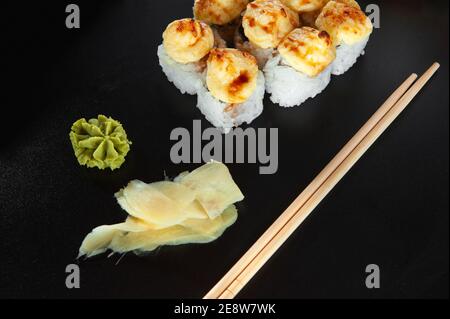 Gebackene heiße Sushi-Brötchen auf dunklem Hintergrund. Hot frittierte Sushi Roll Sushi-Menü. Japanisches Essen. Sehr hochauflösendes Bild Stockfoto