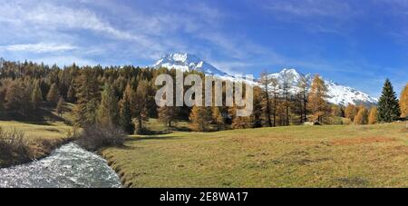 Schöne europäische alpine Berg wtih schneebedeckten Gipfel Hintergrund und Fluss In Panoramasicht Stockfoto