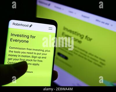 Person, die Smartphone mit der Unternehmenswebsite des US-Finanzdienstleisters Robinhood Markets Inc. Auf dem Display hält. Konzentrieren Sie sich auf den Bildschirm des Mobiltelefons. Stockfoto