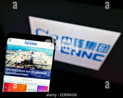 Smartphone mit Firmenlogo der China National Nuclear Corporation (CNNC) auf dem Display vor dem Firmenlogo. Konzentrieren Sie sich auf die Mitte des Telefonbildschirms. Stockfoto