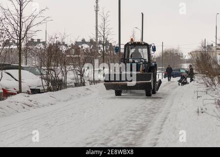 Kleines schneeräumfahrzeug, das schnee auf dem stadtplatz entfernt gelber  oder orangefarbener traktor, der den schnee reinigt