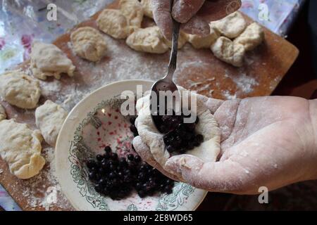 Hausgemachte Knödel sind hässlich mit Heidelbeeren Kochen zu Hause Lebensmittel Verpackung Knödel. Stockfoto