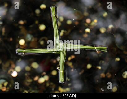 Ein traditionelles St. Brigid's Cross aus Binsen schwebt in St. Brigids' heiligem Brunnen in Co Kildare. Die Menschen besuchen den Brunnen, um den St. Brigid's Day zu feiern, der von vielen in Irland als erster Frühlingstag gesehen wird. Bilddatum: Montag, 1. Februar 2021. Stockfoto