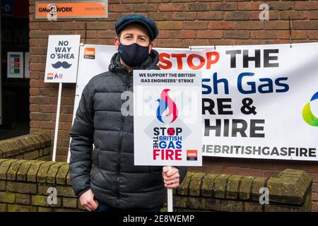 Ein männlicher britischer Gasingenieur bei der GMB Union streikt wegen einseitiger Änderung der Zahlungsbedingungen im Rahmen einer Brand- und Wiederansatzpolitik. Der Protestierende hält ein Plakat, während er vor dem GMB London Regionalbüro in London, Großbritannien, 1st. Februar 2021 stand. Stockfoto