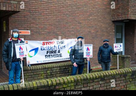 Drei britische Gasingenieure der GMB Union streiken über die einseitige Änderung ihrer Zahlungsbedingungen im Rahmen einer Brand- und Wiederaufbaupolitik. Drei Demonstranten halten Plakate mit Bezug auf Chris O’Shea, den britischen Gas-Chef, während sie vor dem GMB London Regionalbüro in London, Großbritannien, 1st. Februar 2021 standen. Stockfoto