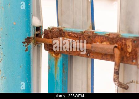 Ein rostiger alter Bolzen an den Metalltüren Stockfoto