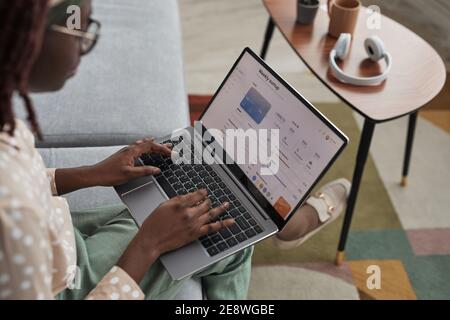 High-Angle-Ansicht auf junge afroamerikanische Frau mit Laptop mit Banking-Service auf dem Bildschirm, Kopierraum Stockfoto