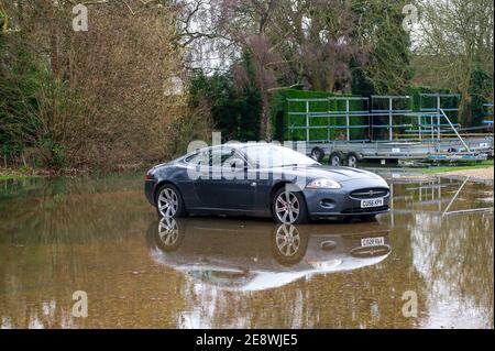 Henley-on-Thames, Oxfordshire, Großbritannien. Februar 2021. Das Wasser kriecht um ein Auto herum, das in der Nähe der Themse parkt. Für die Themse bei Henley gibt es eine Hochwasserwarnung. Es wird davon ausgegangen, dass sich die Sachüberflutung heute fortsetzt, und die Bewohner in der Nähe der Themse wurden gebeten, ihre Hochwasserbarrieren zu aktivieren. Viele der Felder, die für die berühmte Henley Royal Regatta verwendet werden, sind jetzt unter Wasser. Quelle: Maureen McLean/Alamy Live News Stockfoto