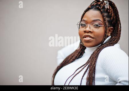 Glamouröse afroamerikanische Frau in weißen Rollkragenpullover Pose auf der Straße. Stockfoto