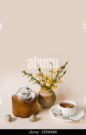 Ostern Kuchen Handwerk in. Basteln Sie mit Rosinen, kandierten Früchten und einem Spritzer Puderzucker. Hausgemachter Kuchen. Eier, eine Tasse Tee und Frühlingsblumen in einem V Stockfoto