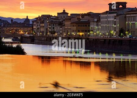 Ein Kanufahrer, der sich am Fluss arno von florenz in der Nähe des pescaia (Wehr) von san Niccolò bei Sonnenuntergang, italien, entspannt Stockfoto