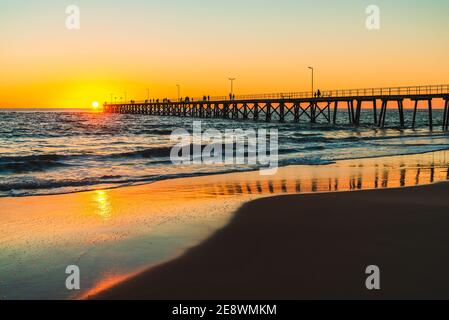 People Silhouetten auf Port Noarlunga Anlegestelle vom Strand bei Sonnenuntergang, South Australia Stockfoto