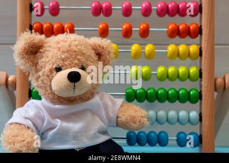 Kinder lernen zählen, Kinder Mathe Klasse Konzept. Niedlichen Teddybär, Schule Abacus mit bunten Perlen Hintergrund Stockfoto