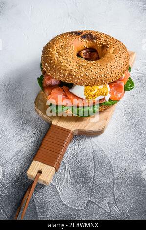 Bagel mit gesalzenem Lachs, Frischkäse, Avocado und Ei. Grauer Hintergrund. Draufsicht Stockfoto