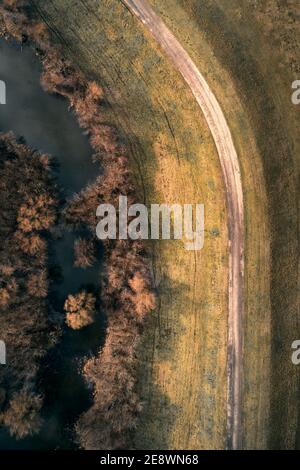 Luftaufnahme der kurvenreichen Straße und sumpfigen Fluss Oxbow Landschaft, Draufsicht von Drohne pov. Fluss Tisza (Tisa) in der Vojvodina, Serbien. Stockfoto