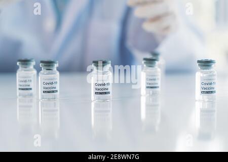 COVID-19 Coronavirus-Impfstoffröhrchen mit Arzt hinten mit Kopierraum. Healthcare und Medizin Konzept Stockfoto