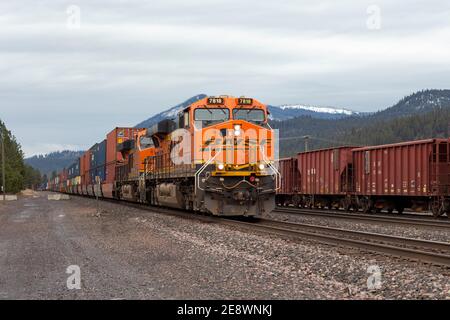 Eine BNSF Zug Diesel-elektrische Lokomotive zieht eine Linie von Container-Brunnen Autos durch die Werft in Troy, Montana. Burlington Northern und Santa Stockfoto
