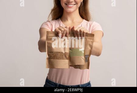 Umweltfreundliches Paket. Frau hält braune Kraftpapier Doypack Taschen mit Gewicht Lebensmittel Stockfoto