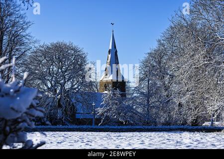 Eine Winterszene über einem Feld nach Schnee von All Saints Dorfkirche, Souldrop, Bedfordshire, England, Großbritannien Stockfoto