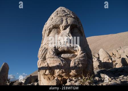 Eine Nahaufnahme eines alten Steinkopfes am Mount Nemrut, Türkei, enthüllt die verwitterten Details und den geheimnisvollen Ausdruck, der von erfahrenen Handwerkern geschnitzt wurde. Stockfoto