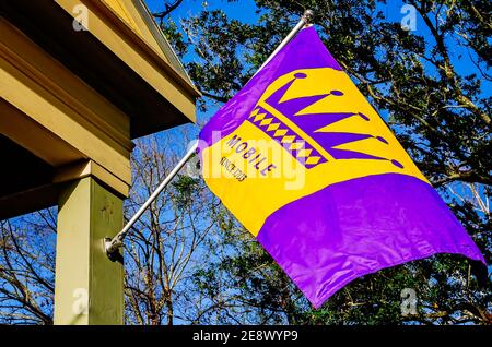 Eine Mardi Gras Fahne in traditionellem Royal Purple und Gold hängt von einem Haus in der Church Street, 31. Januar 2021, in Mobile, Alabama. Stockfoto