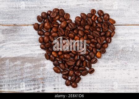 Herz aus Kaffee und Eheringen. Stockfoto