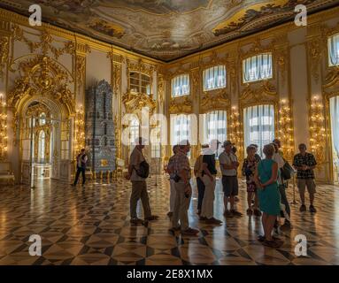 St. Petersburg, Russland -- 22. Juli 2019. Die Touristen hören dem Führer zu, wie er sie im Zimmer des Sommerpalastes Katharinas des Großen anspricht Stockfoto