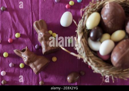 Draufsicht auf Schokoladenhasen und Nest mit ostereiern Stockfoto