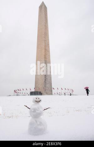 Ein netter kleiner Schneemann lächelt Besucher vor dem Washington Monument an einem verschneiten Wintertag in Washington, D.C. an Stockfoto