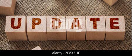 Aktualisieren Wort auf einem Holzwürfel auf burlap Leinwand Hintergrund. Business Technologies Fertigungskonzept. Stockfoto