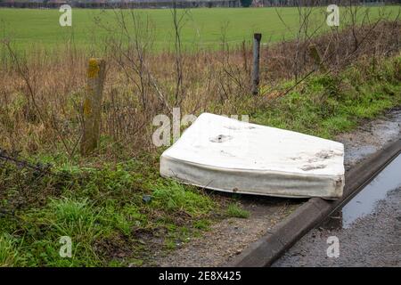 Eine alte schmutzige Doppelmatratze wurde auf die Seite gedumpt Die Straße in Mitte Norfolk England Großbritannien Stockfoto