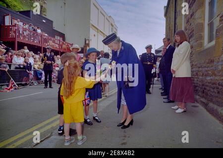 Königin Elizabeth II. Erhält Blumenstrauß von Kindern während ihres Besuches in Hastings Old Town, East Sussex, England, Großbritannien. 6. Juni 1997 Stockfoto