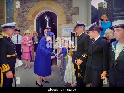 Königin Elizabeth II. Nimmt einen Blumenstrauß von Kindern vor dem Fishermen's Museum bei ihrem Besuch in Hastings Old Town, East Sussex, England, UK, entgegen. 6. Juni 1997 Stockfoto