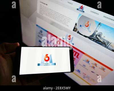 Person, die ein Smartphone mit dem Geschäftslogo der französischen Medienholding Metropole Télévision S.A. (Groupe M6) auf dem Display hält. Konzentrieren Sie sich auf den Telefonbildschirm. Stockfoto