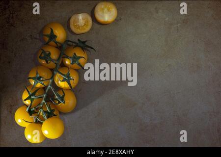 Gelbe Kirschtomaten am Rebstock Stockfoto