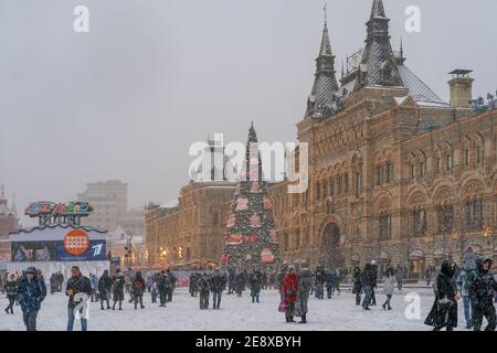 Schneefall in Moskau.Menschen, die Winterwetter und urbane weihnachtsdekorationen genießen, wandern auf dem Roten Platz in starkem Schneesturm auf und ab. Stockfoto