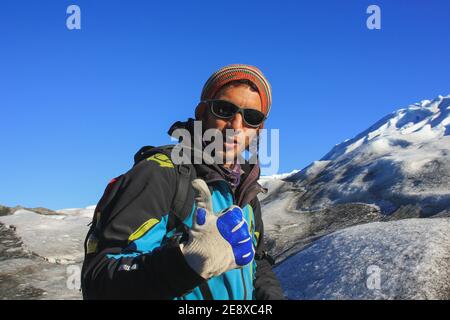 Porträt eines gutaussehenden hispanischen Los Glaciares National Park Guide in alpiner Kletteruniform und Ausrüstung, der auf dem Glacier bleibt und die Kamera anschaut Stockfoto