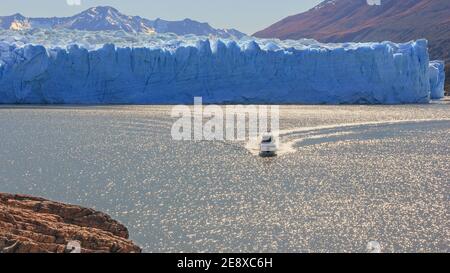 Panoramablick auf die Gletscherlandschaft mit Touristenboot Blendung verschwommene Oberfläche des Sees in Sonne Blendung in der Nähe berühmt Schmelzender Perito Moreno Gletscher Stockfoto