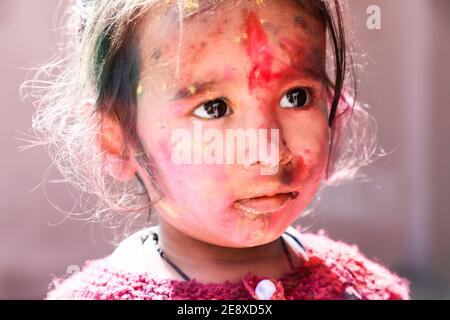 Portrait of Kid Gesicht voller Farbe beim Spielen mit Farbe während holi Festival der Farben Stockfoto