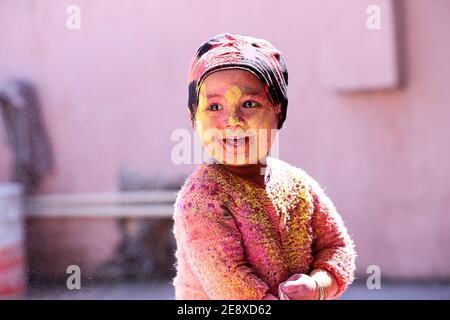 Indian Kid lächelndes Porträt spielt mit Farben bei der Gelegenheit Von holi Farbe des Festivals Stockfoto