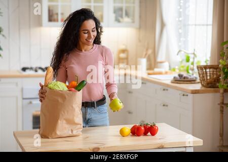 Junge Frau Auspacken Papierbeutel Mit Gemüse Und Obst Nach Lebensmittelgeschäfte Stockfoto