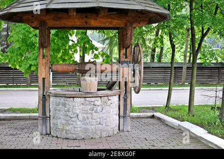 Nahaufnahme eines alten hölzernen traditionellen Brunnenes auf dem Land. Stockfoto