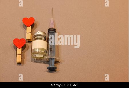 Valentinstag Hintergrund. Rote Herzen Liebe mit medizinischen Spritze und Valentinstag Konzept auf einem isolierten grauen Hintergrund mit Raum. Stockfoto