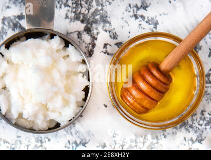 Hausgemachte Haarmaske aus Kokosnussbutter und Honig - Weißer Hintergrund Stockfoto